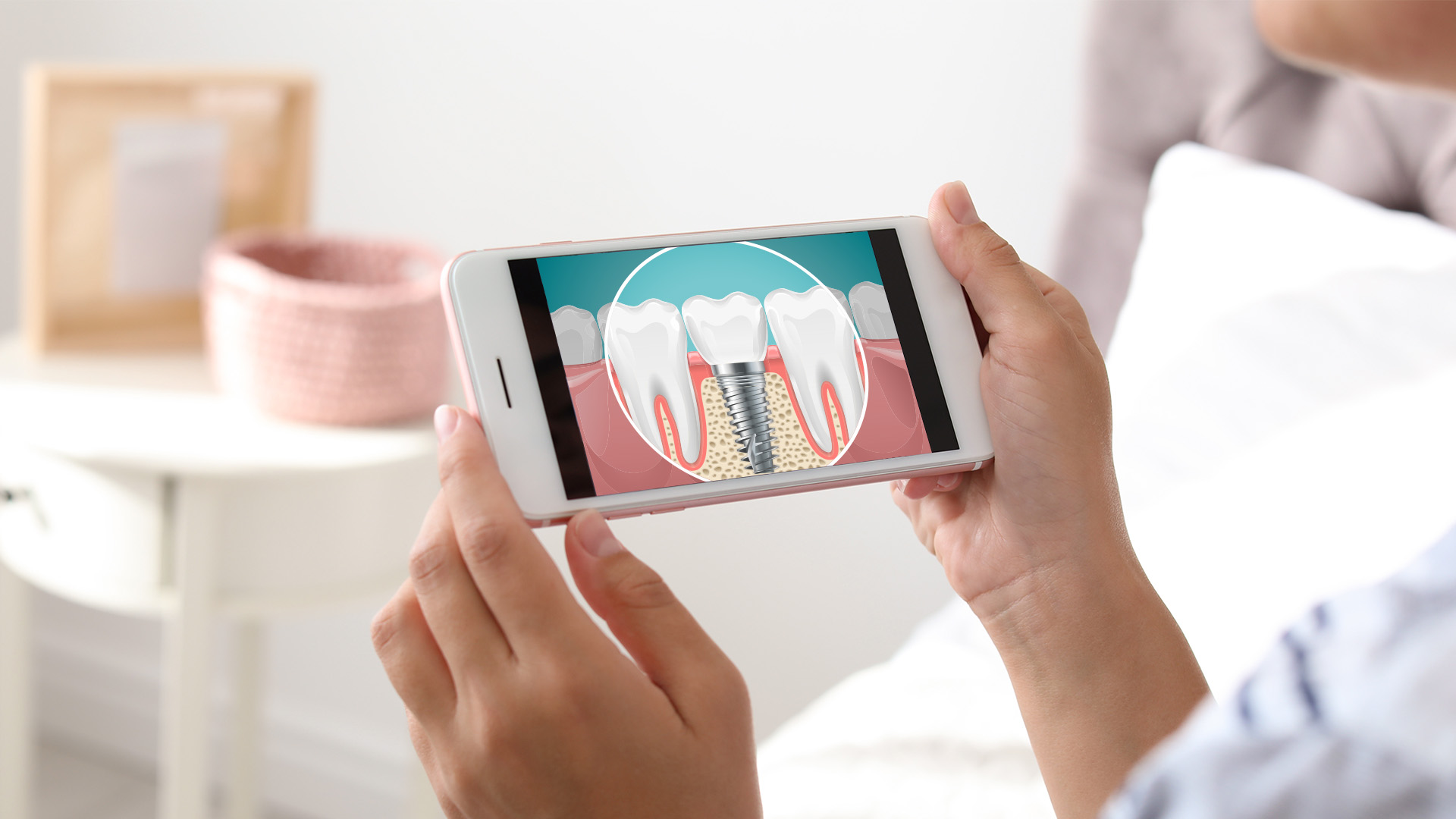 The image shows a person holding a smartphone with an app open, displaying a 3D model of a tooth with a cavity highlighted, indicating dental care or oral health education content on the screen.