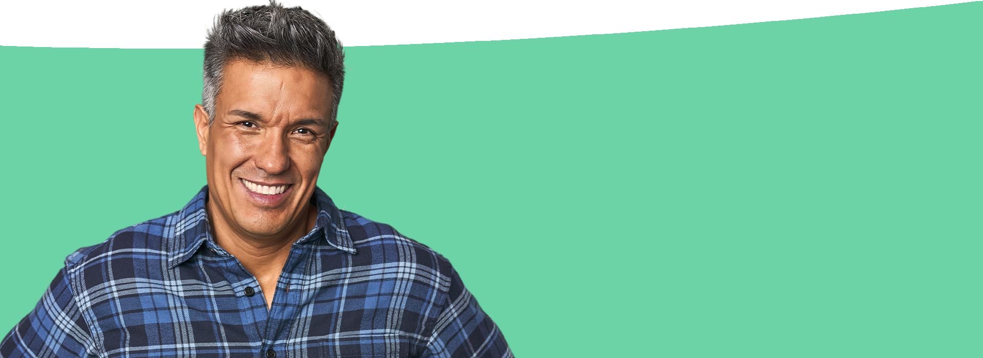 The image features a man with a beard wearing a plaid shirt, standing against a green background, with a watermark visible on the lower right corner.