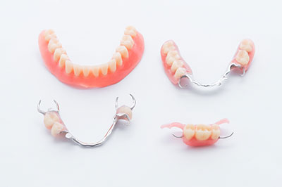 Alt text   A collection of dental implants with teeth crowns displayed on a white background.