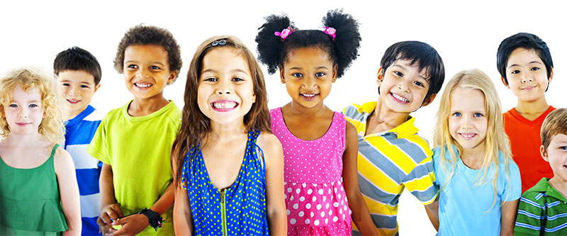 The image shows a group of children of various ages and ethnicities smiling at the camera, with some standing and others sitting, wearing colorful clothing.